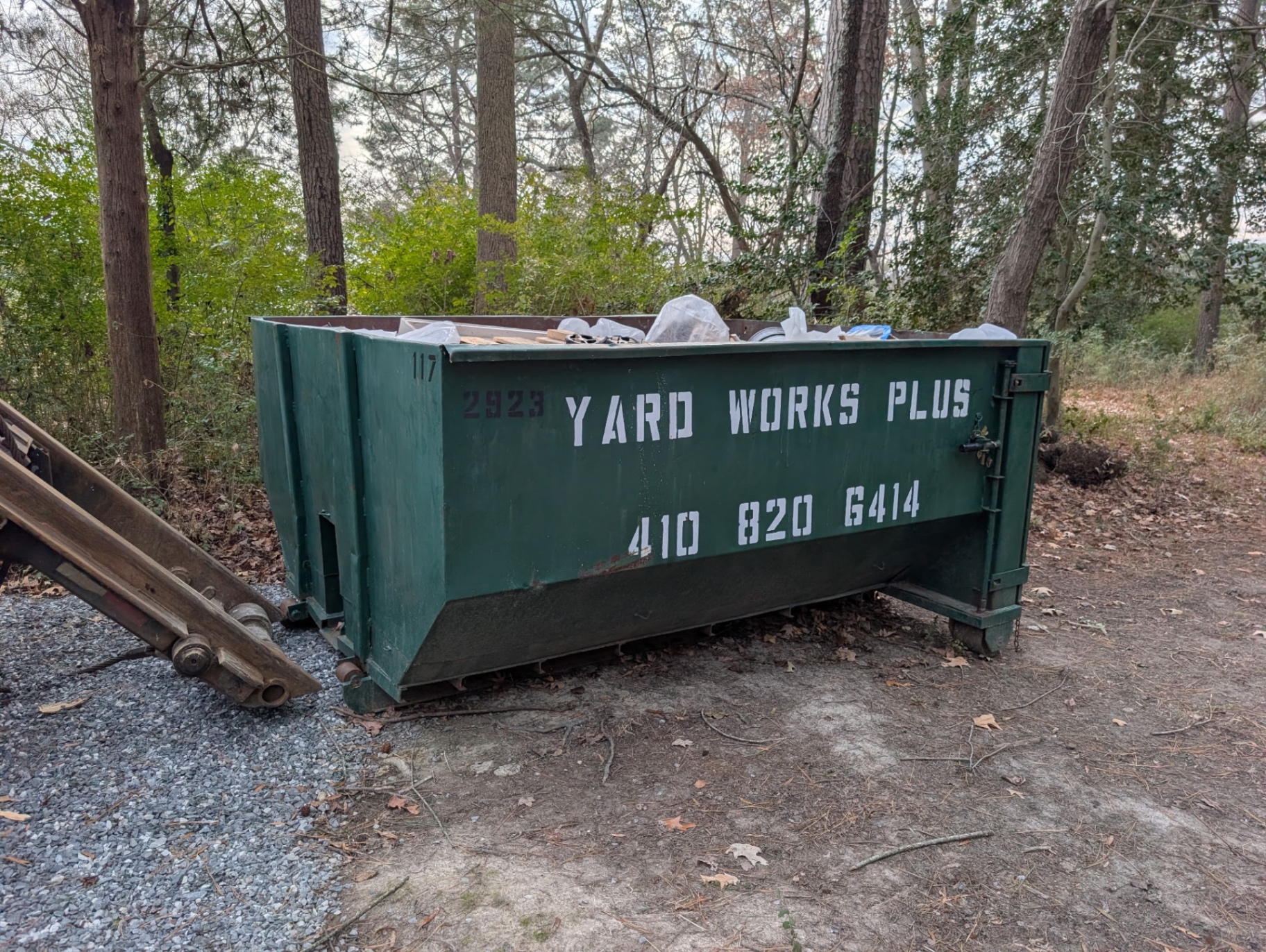 10 yard dumpster filled with debris on a wooded property in Easton MD