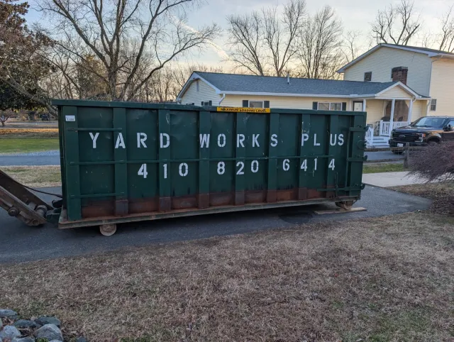 Green roll-off dumpster delivered to a residential driveway in Salisbury, Maryland